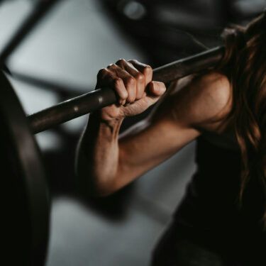 woman lifting weights on shoulder