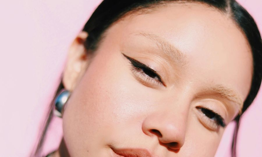 zoomed in woman face and eyes on pink background