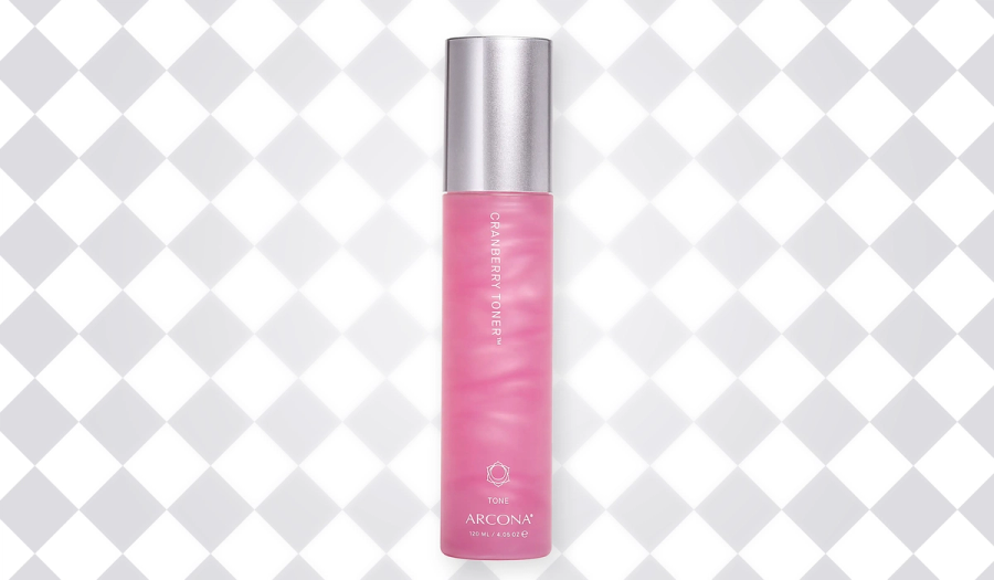 Pink bottle of ARCONA Cranberry Toner with a silver cap against a white-and-gray diamond-patterned background.