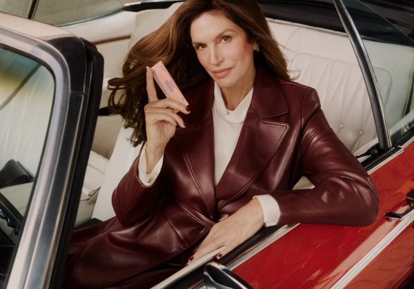 Cindy Crawford holds Upneeq while sitting in a car for the brand’s campaign