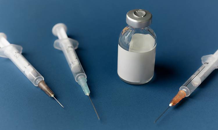 syringes and vials on blue background