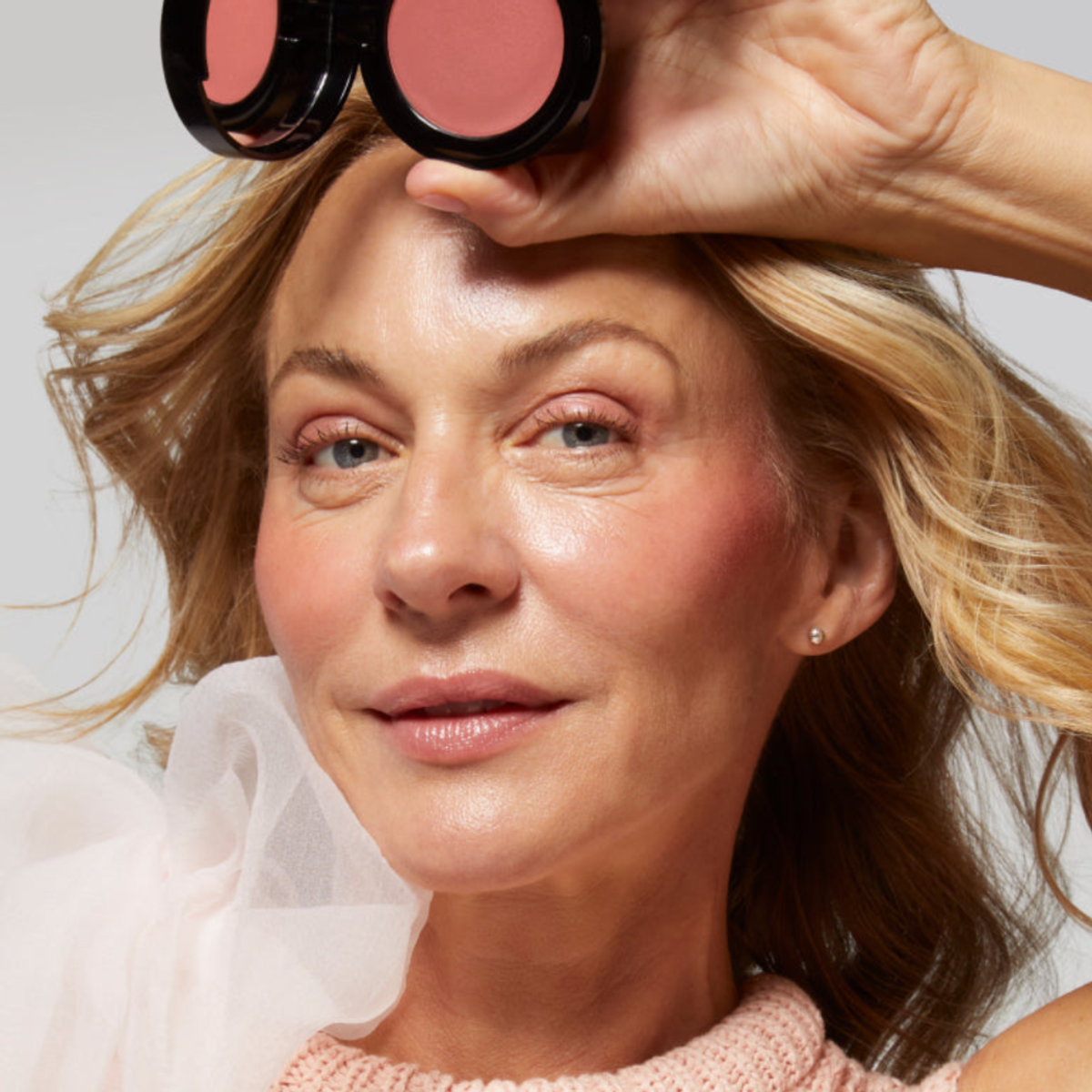 woman holds Laura Geller Beauty Wonder Balm