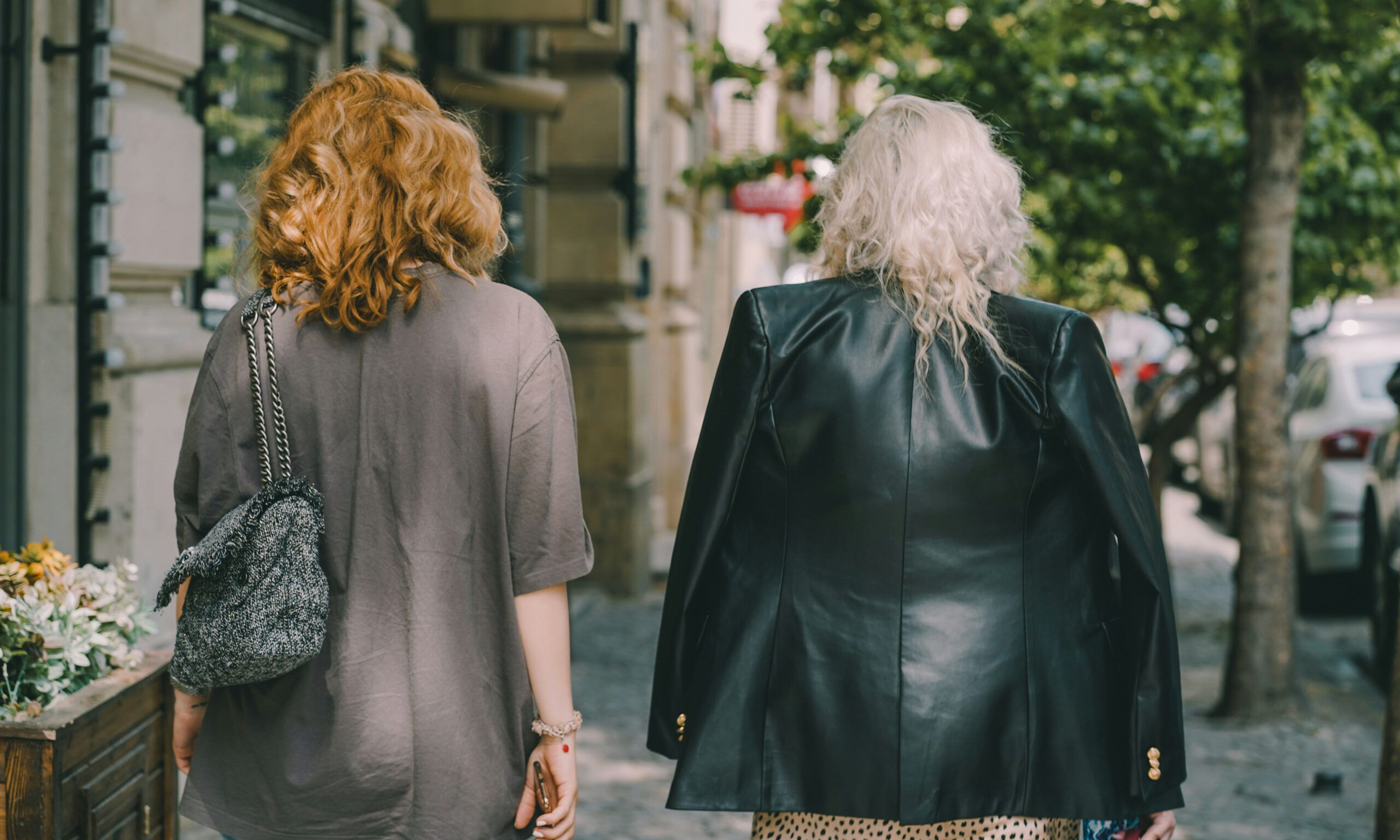 back view of two middle aged women walking in a city
