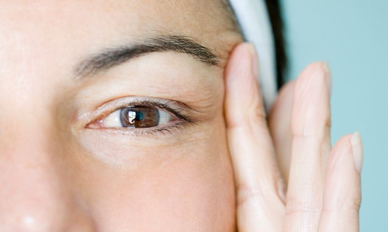 Woman pulling skin of the face