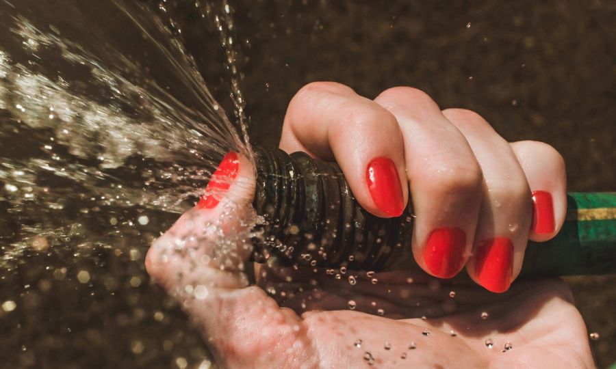 Woman holding hose, woman with red nail polish