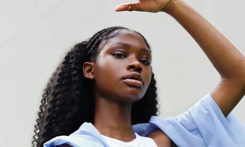a woman in a white top and a blue jacket raising arms