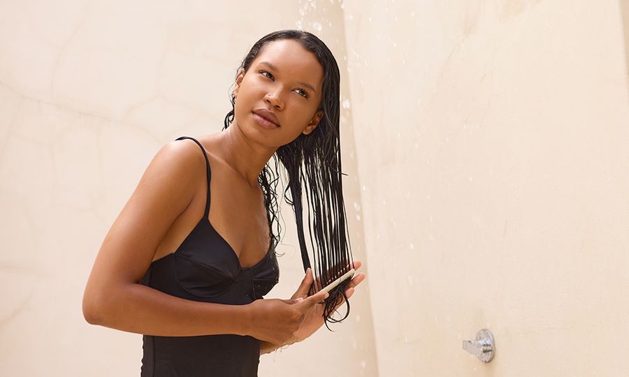 Long Hair Shower Relaxation: Woman Gently Combing Wet Hair Under Refreshing Water Stream. Calm, Reflective Mood, Emphasizing Self-Care, Tranquility, and Natural Beauty In Outdoor Setting. Ideal For Wellness And Beauty Themes.