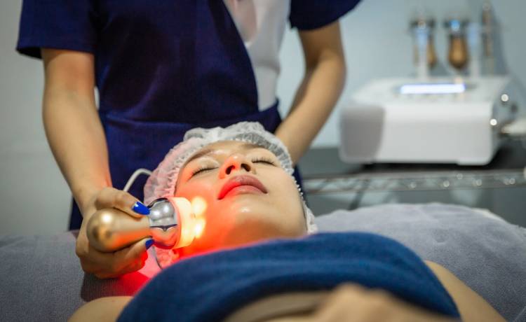 Patient undergoing a professional facial treatment with a handheld device to improve skin texture, boost collagen and support cosmetic rejuvenation