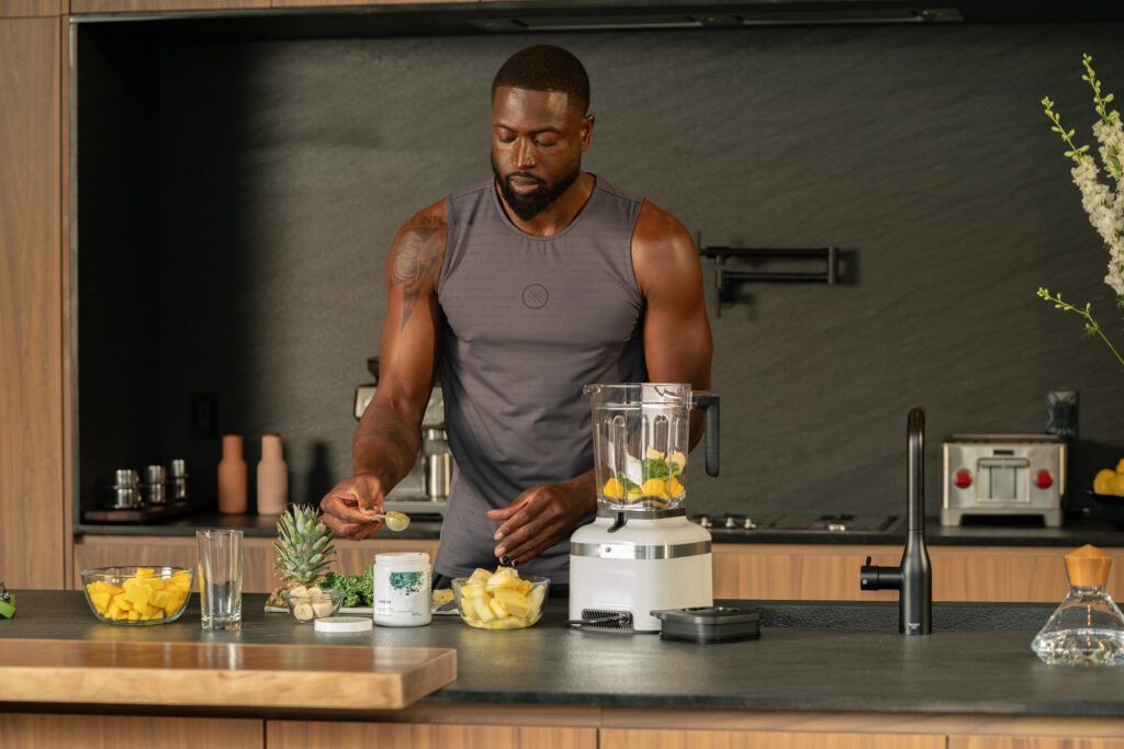 Dwayne Wade making a smoothie with fruits, vegetables and Thorne supplement powder