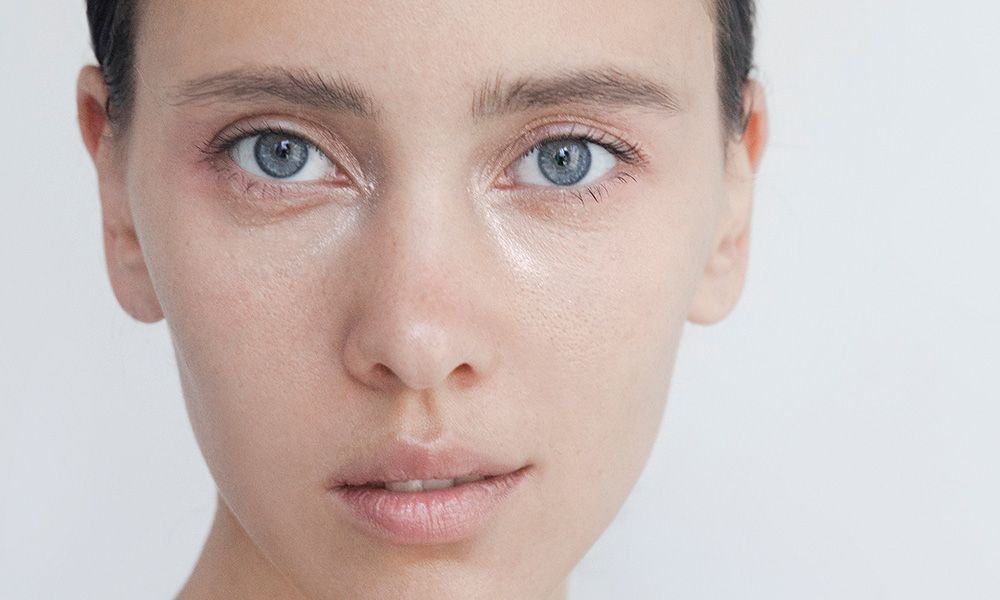 Beautiful young woman close-up portrait Captivating Brunette with blue eyes Pure Perfection Natural beauty Looking at camera Headshot Fashion model studio portrait Natural no-make-up look Soft skin Gentle kind look