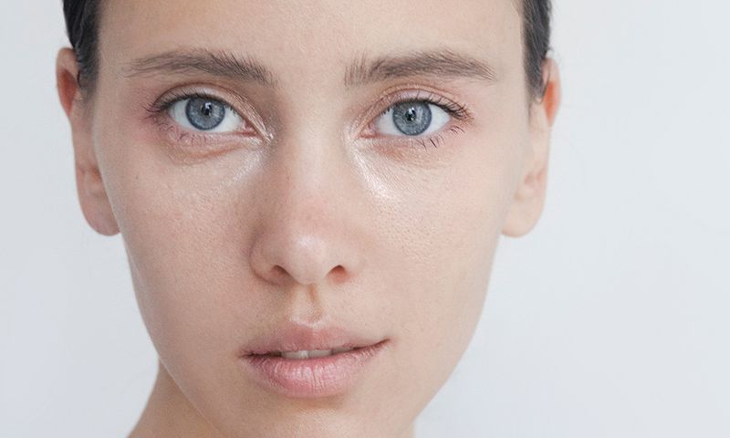 Beautiful young woman close-up portrait Captivating Brunette with blue eyes Pure Perfection Natural beauty Looking at camera Headshot Fashion model studio portrait Natural no-make-up look Soft skin Gentle kind look