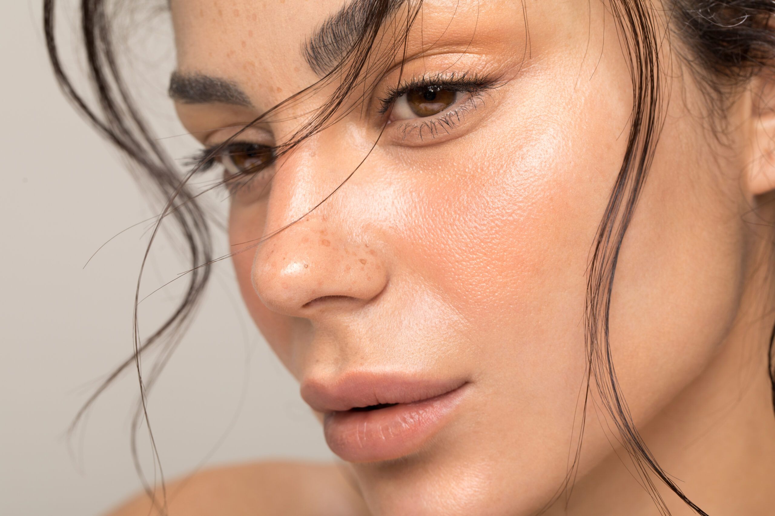 Close up studio shot of a beautiful natural blonde woman with freckles skin.