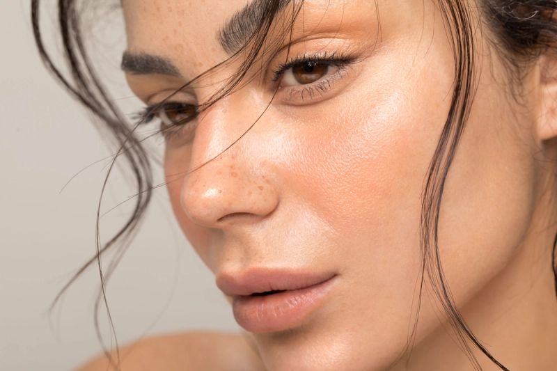 Close up studio shot of a beautiful natural blonde woman with freckles skin.