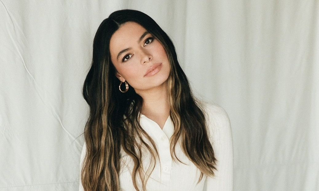 Miranda Cosgrove poses in white blouse