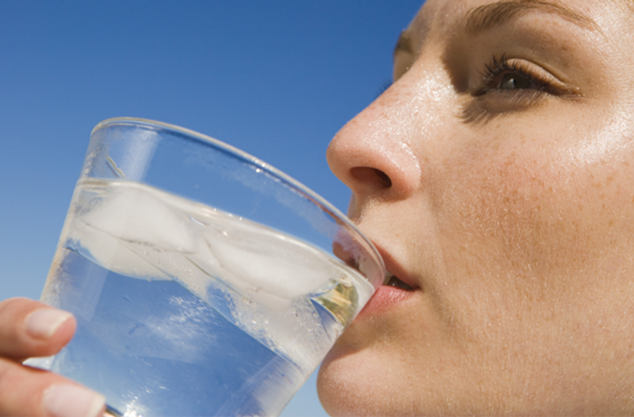 Woman outdoors drinking ice water