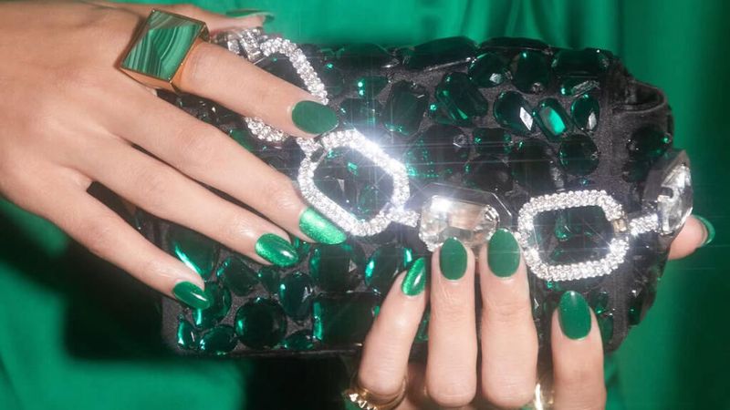 A short manicure with shimmery green nails