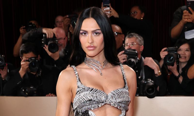 Amelia Gray Hamlin wearing a silver embellished gown and diamond choker necklace on the red carpet, posing in front of photographers