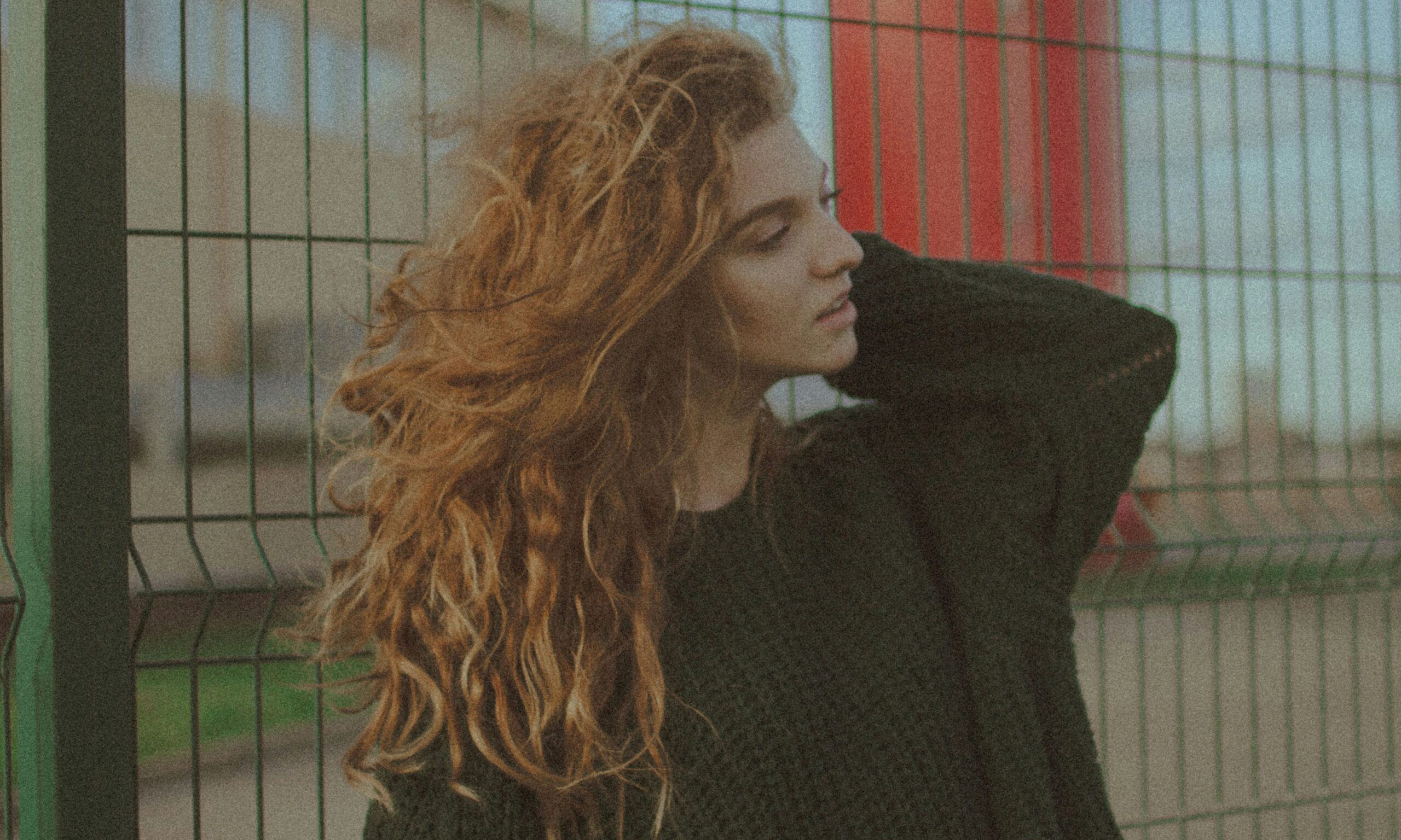 woman in black sweater with long red wavy hair