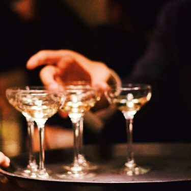 hand grabbing champagne glasses from a tray