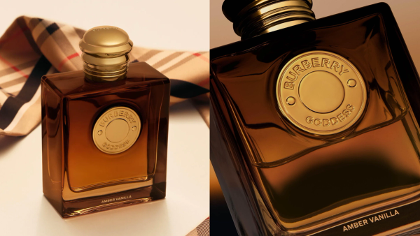 Two Burberry Goddess Amber Vanilla perfume bottles with amber glass and gold caps, displayed against a beige background with Burberry check fabric.