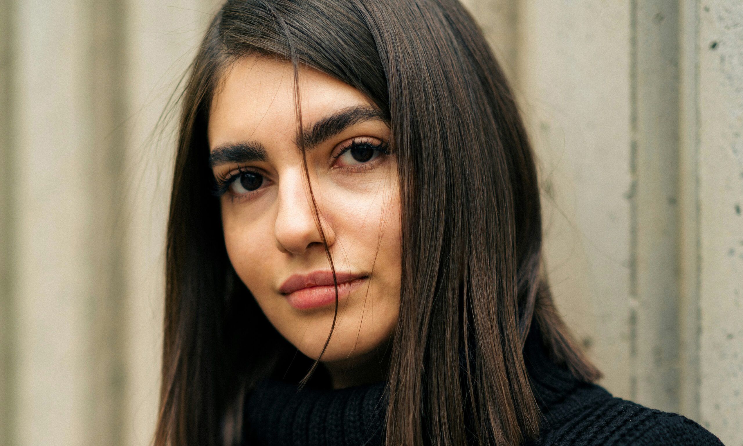 brown-haired woman with wind-swept hair