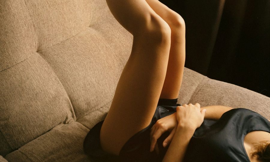woman on couch with her legs in the air