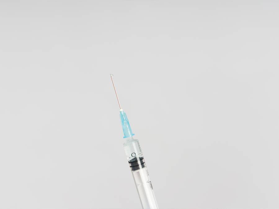 syringe against a gray background