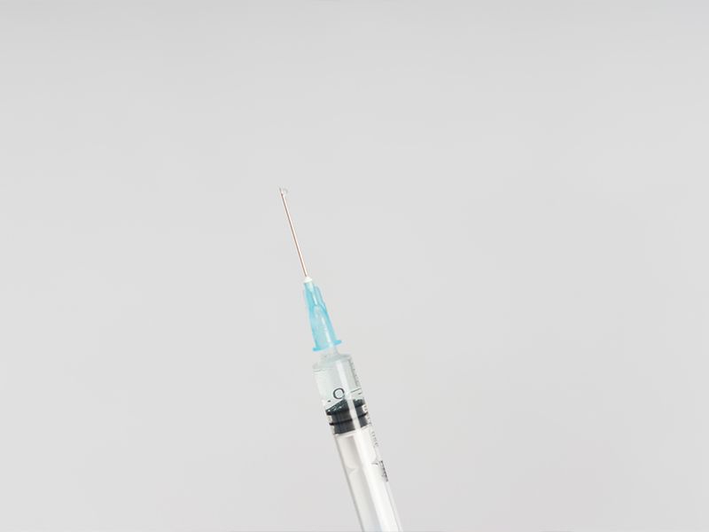 syringe against a gray background