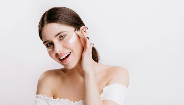 woman applying cream to her skin