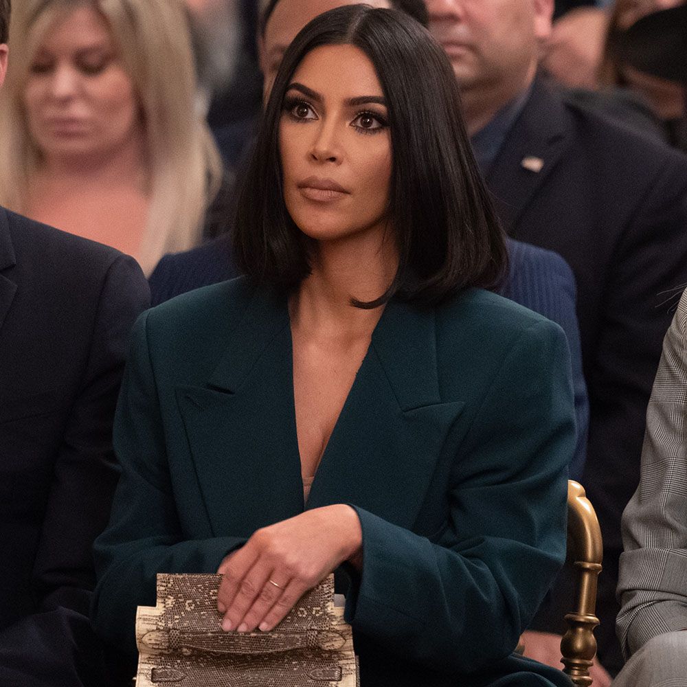 Kim Kardashian sitting down with short bob hairstyle and wearing a blazer
