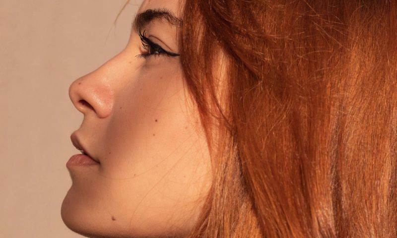 woman with red hair looking to the side