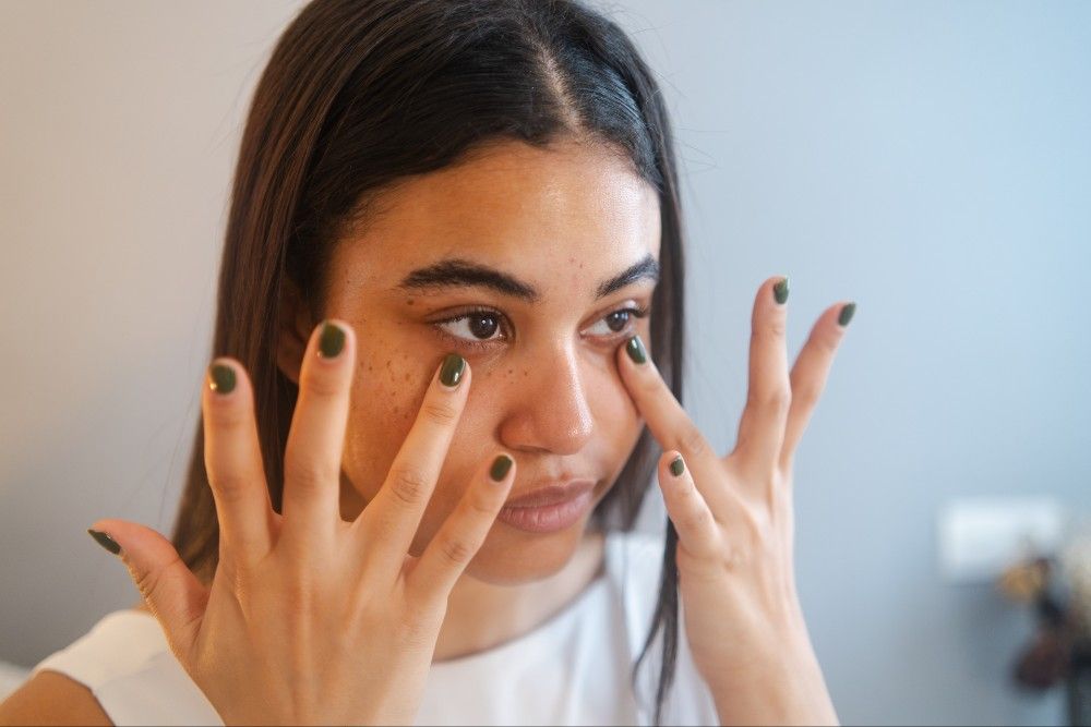 woman applying eye product to undereyes