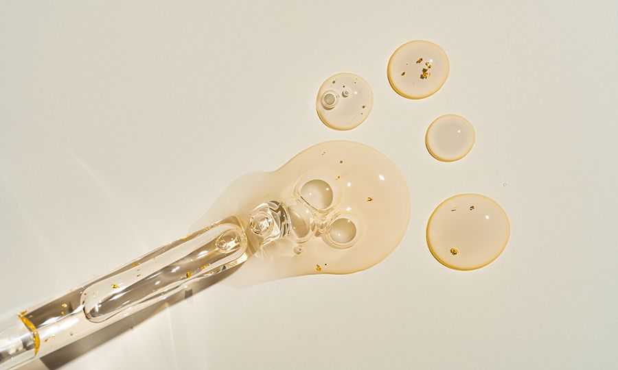 Top-view mockup of a glass dropper bottle with cosmetic pipette on trendy beige backdrop. Harsh sunlight accentuates the organic beauty product's premium packaging for clean cosmetics branding.