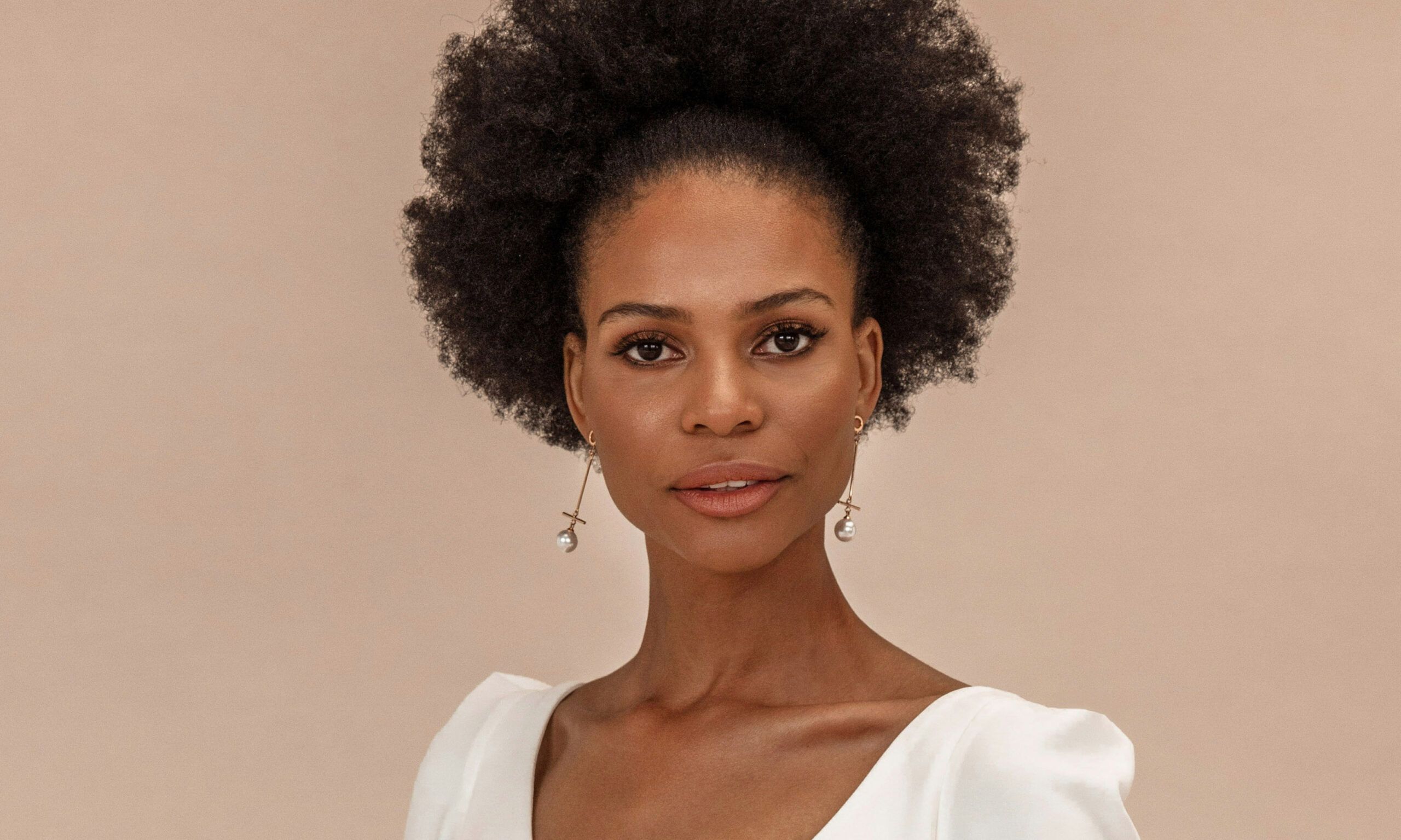 woman with afro in a white dress
