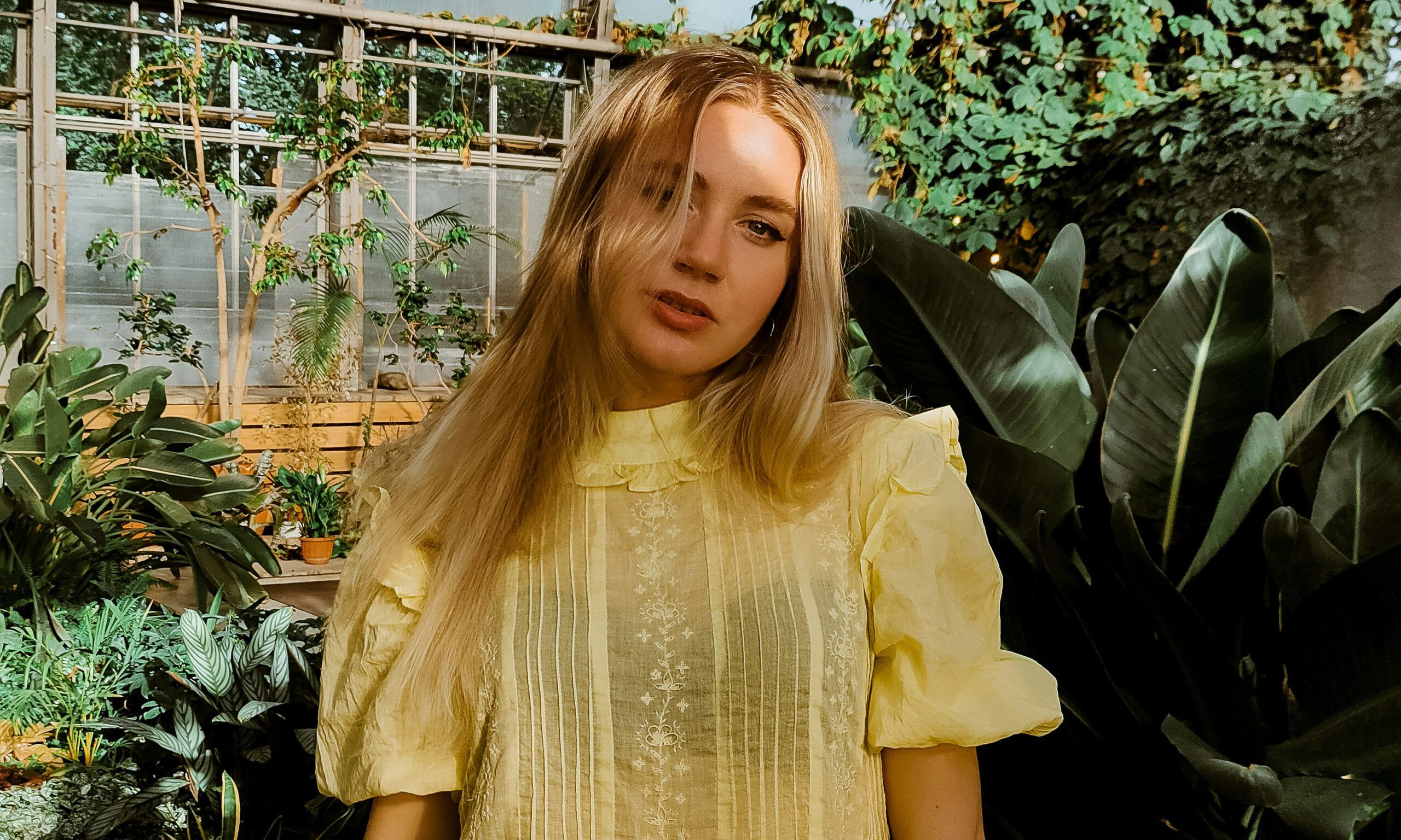 woman in yellow lace dress standing in a garden