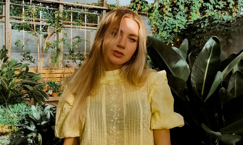 woman in yellow lace dress standing in a garden