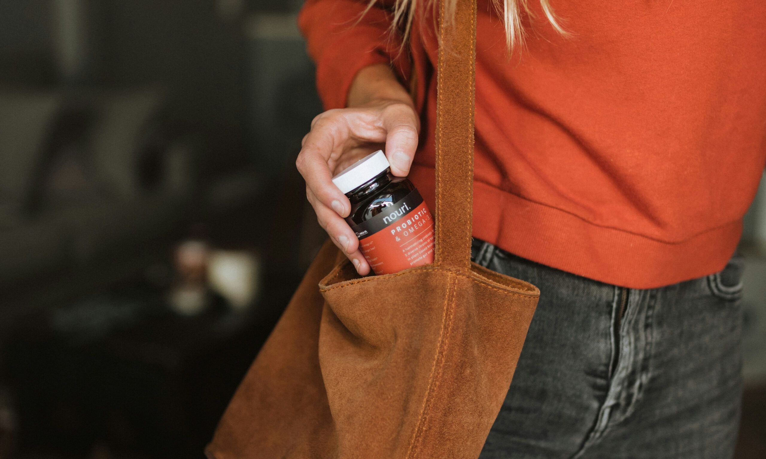 woman taking supplement bottle out of bag