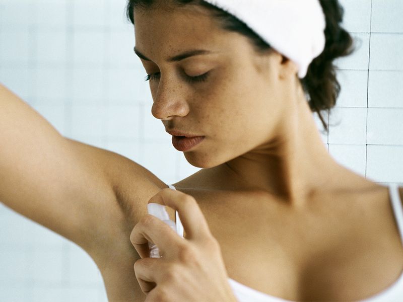 woman applying deodorant