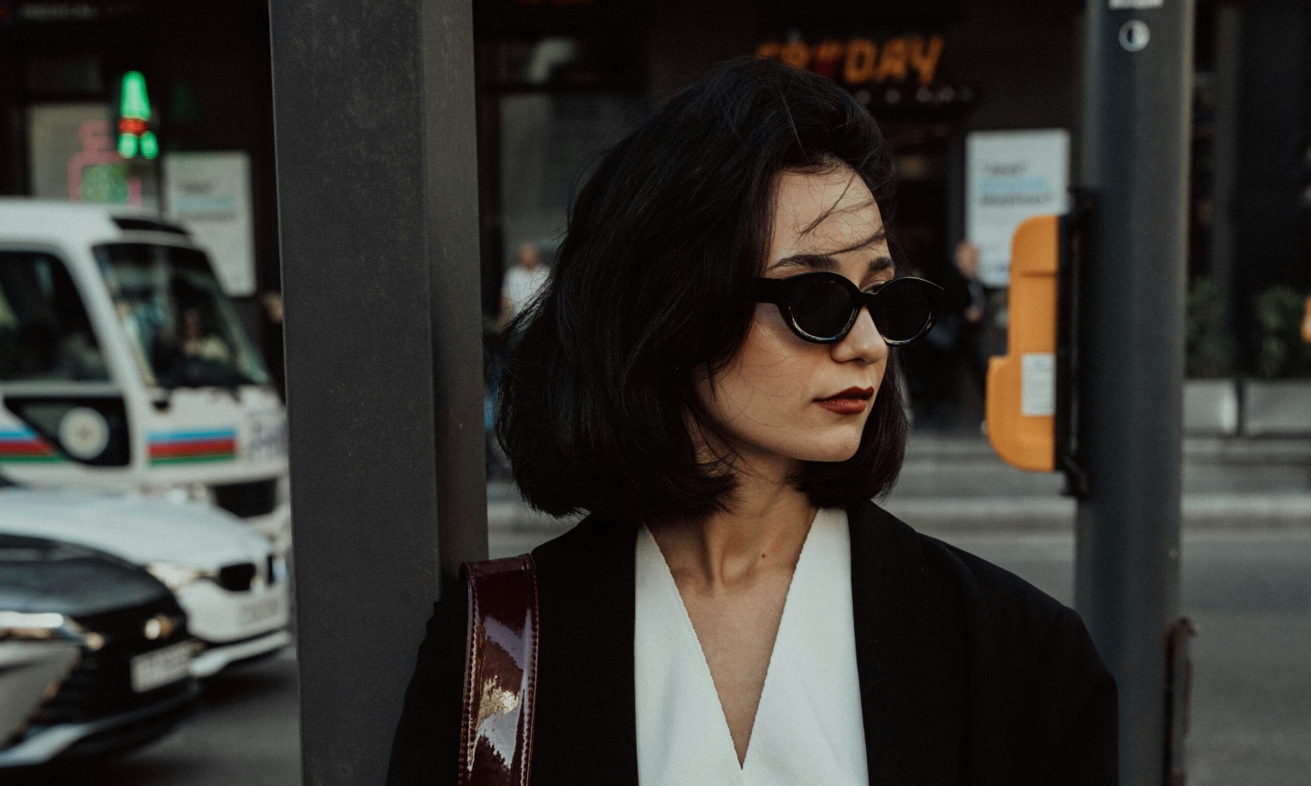 woman with brunette bob standing on a city street