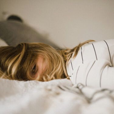 Woman laying face down on bed