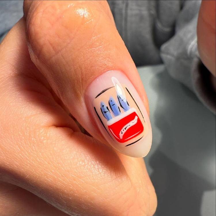 Close-up of a short sheer nude nail with detailed nail art depicting a tin of blue sardines in a red and white can, on a bare nail base