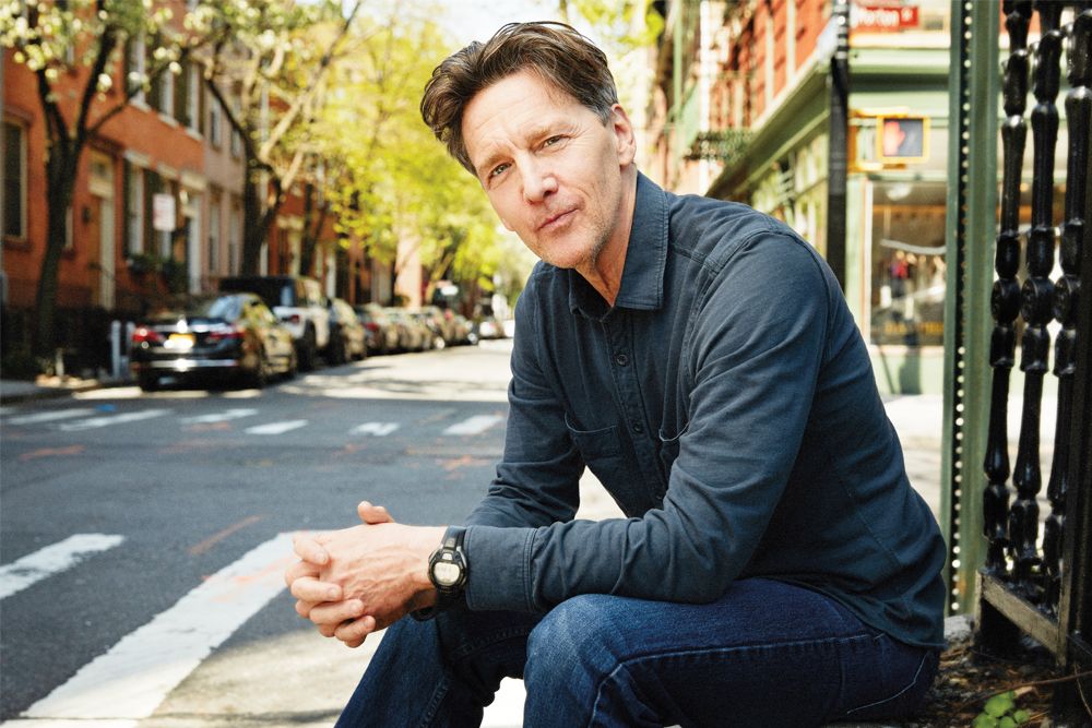 Andrew McCarthy sitting outdoors