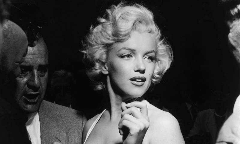 Actress Marilyn Monroe surrounded by reporters and fans outside Grauman's Chinese Theater in Hollywood, California.