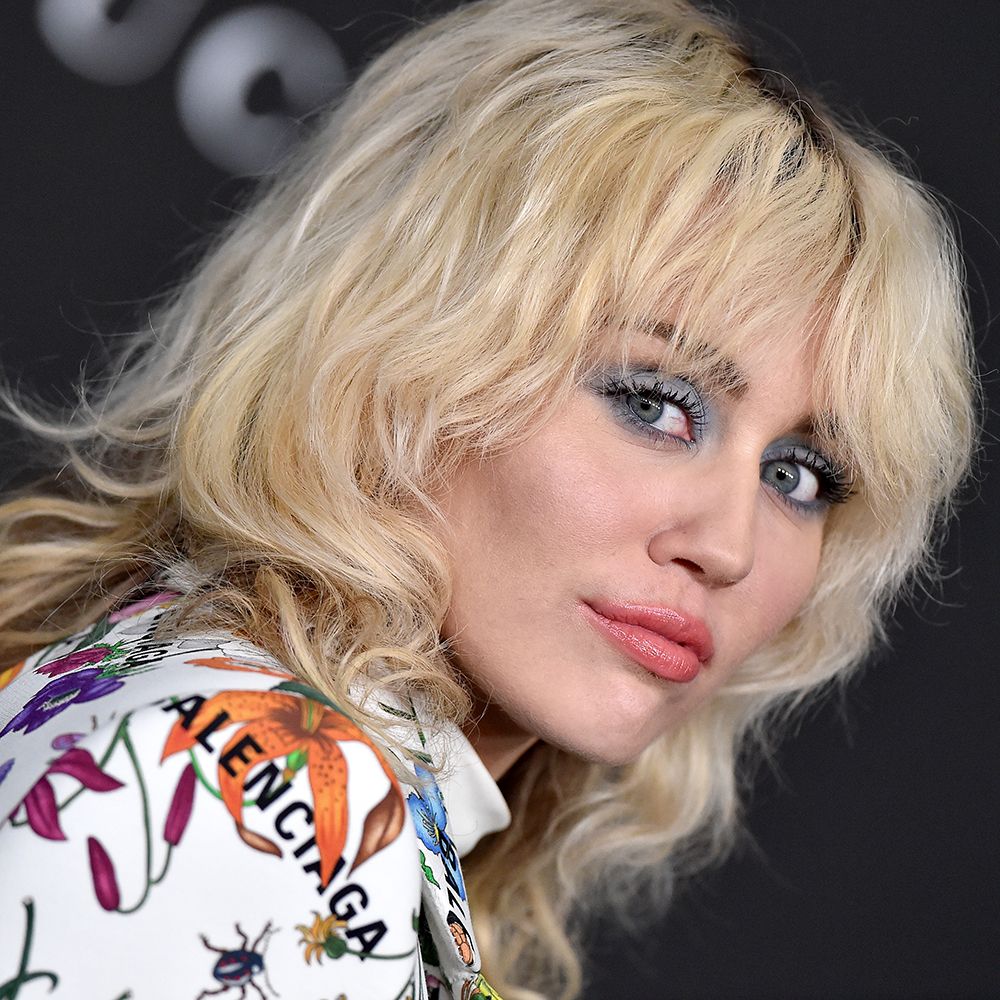 Miley Cyrus with blonde 70s shag hair on the red carper