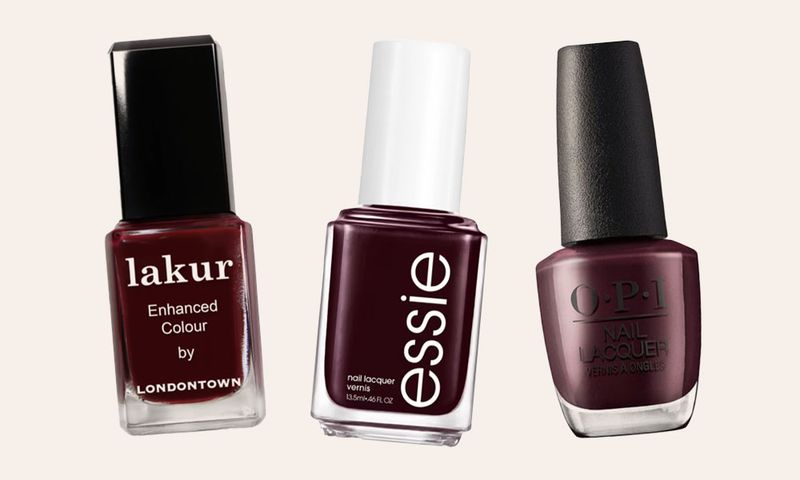 Three bottles of black cherry color nail polishes on an off-white background