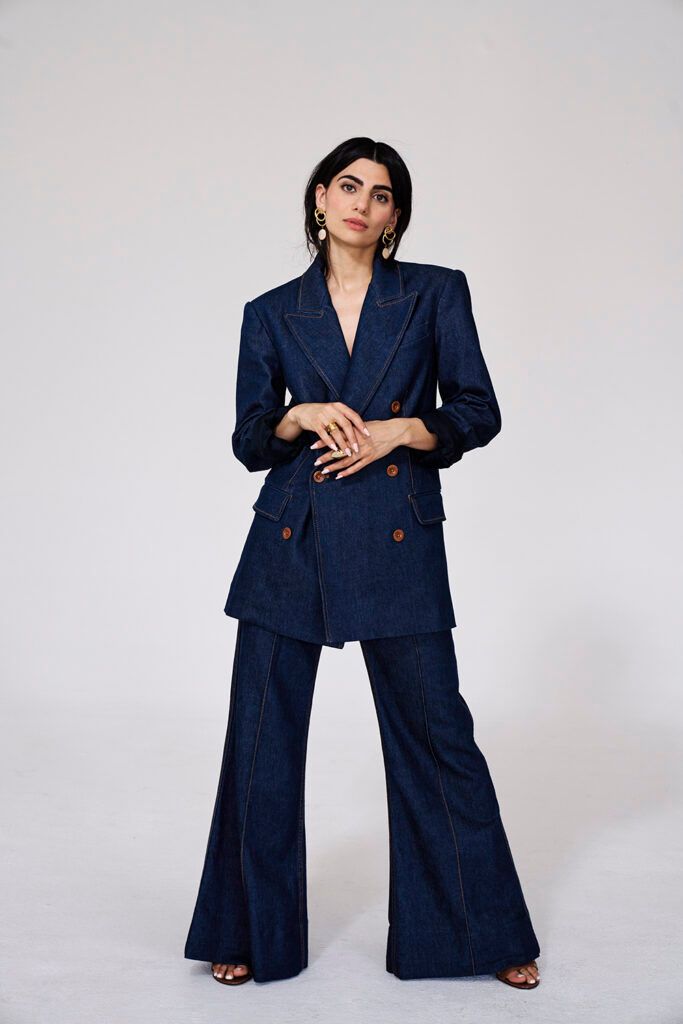 Claudia Doumit posing in a two-piece navy suit