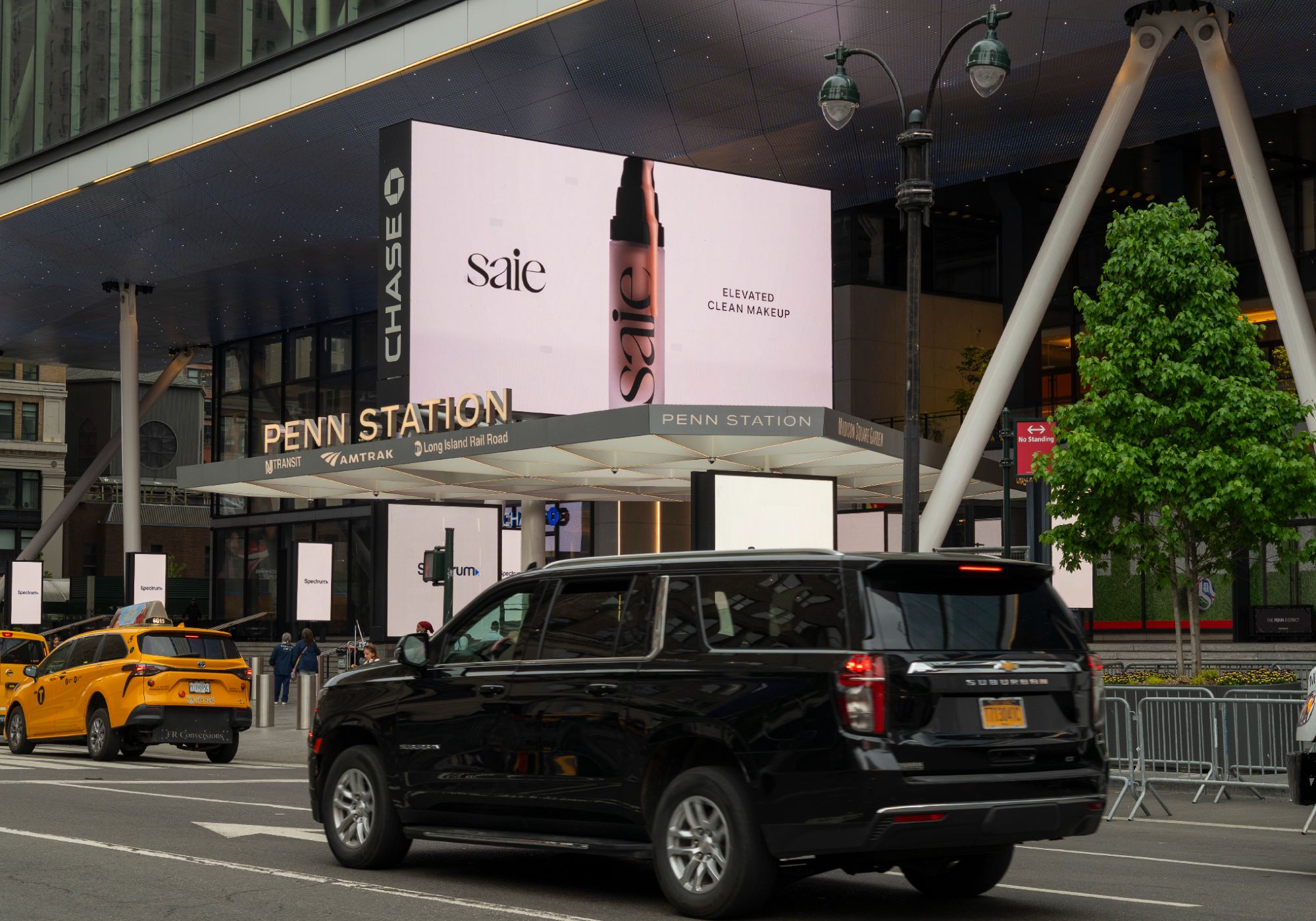Saie "Elevated Clean Makeup" billboard displayed on the exterior of Penn Station in New York City.