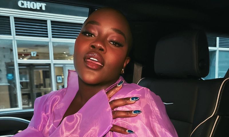 woman wearing purple in the back of a car