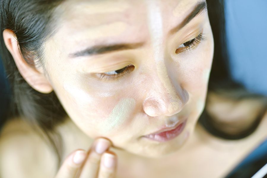 woman using color correcting makeup on face