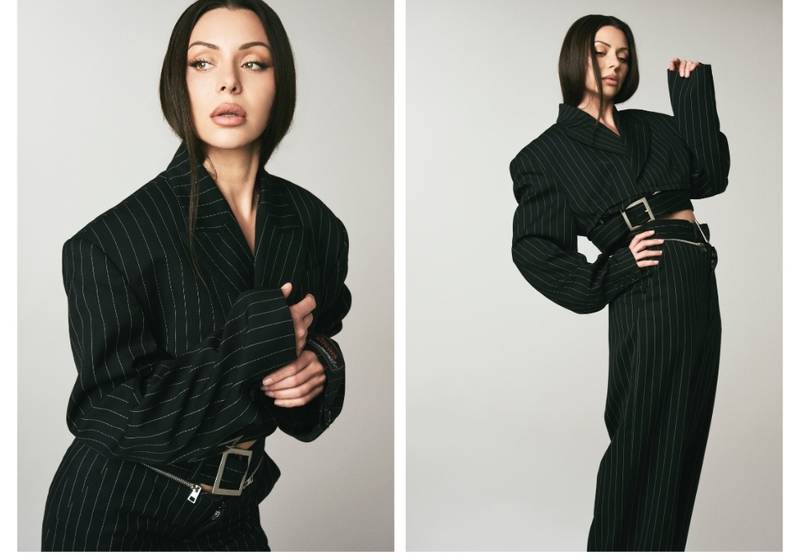 Side-by-side studio portraits of actress Neraida Bega wearing a black pinstripe suit, featuring a close-up beauty look and a full-body pose, highlighting her sleek hair and natural makeup